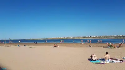 a group of people laying on the beach at Studio cabine avec jardinet à 30 m de la plage, au calme. in Gruissan