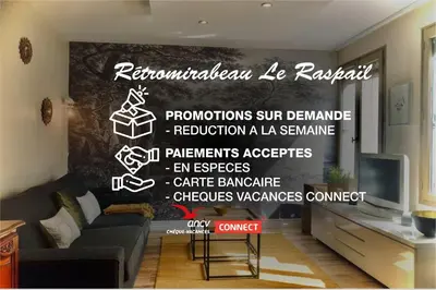 a living room with a couch and a tv at RétroMirabeau 
