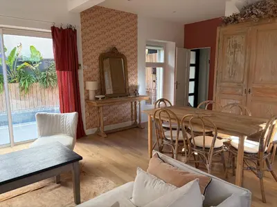 a living room with a blue couch and a table at La maison cocooning in Narbonne