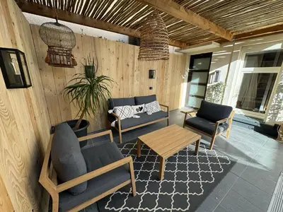 a living room with a table and chairs at La maison cocooning in Narbonne
