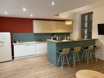 a kitchen with a counter and bar with stools at Le Bout du Monde Appartement Hyper-centre in Carcassonne