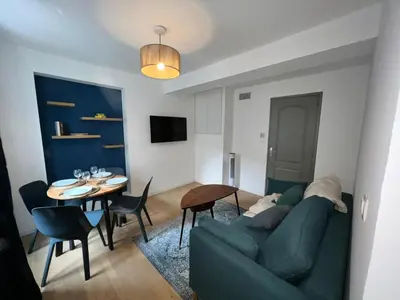 a living room with a green couch and a table at Le Rêve Bleu Appartement Hyper-centre in Carcassonne