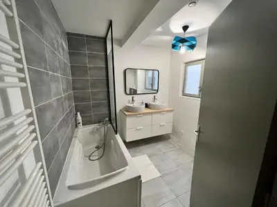 a bathroom with a tub and a sink and a mirror at Le Rêve Bleu Appartement Hyper-centre in Carcassonne