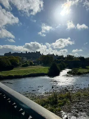a bridge over a river with the sun in the sky at Le studio Hyper-centre in Carcassonne