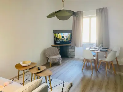 a living room with a table and chairs and a tv at Le studio Hyper-centre in Carcassonne