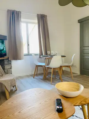 a living room with a table and chairs and a television at Le studio Hyper-centre in Carcassonne