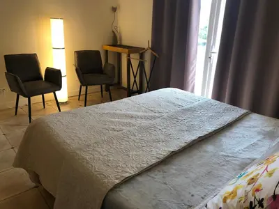 a bedroom with two chairs and a bed and a window at Le Nid des Corbières in Bizanet