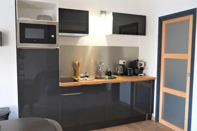 a kitchen with a wooden counter with a microwave at A l'ombre des remparts in Carcassonne