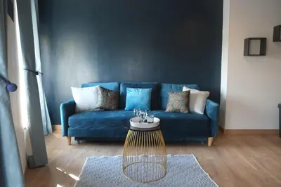 a blue couch in a living room with a table at A l'ombre des remparts in Carcassonne