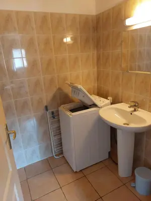 a bathroom with a sink and a trash can at GIte place République in Pézilla-de-Conflent