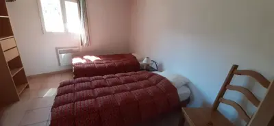 a bedroom with a bed with red sheets and a window at GIte place République in Pézilla-de-Conflent