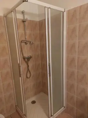 a shower with a glass door in a bathroom at GIte place République in Pézilla-de-Conflent