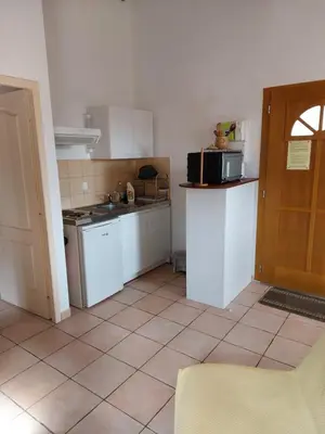 a kitchen with white appliances and a tile floor at GIte place République in Pézilla-de-Conflent