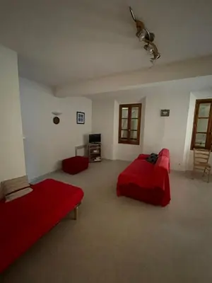 a large room with two beds and a tv at Gîte communal presbytère in Pézilla-de-Conflent