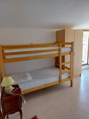 a bedroom with bunk beds with a desk and a lamp at Gîte communal presbytère in Pézilla-de-Conflent