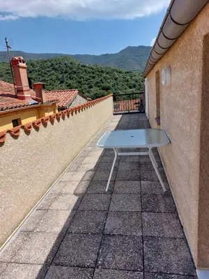 a bench sitting on the side of a balcony at Gîte communal presbytère in Pézilla-de-Conflent