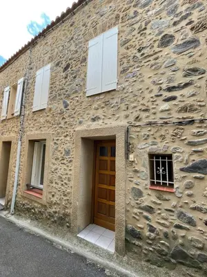a stone building with a door and windows at Gîte communal presbytère in Pézilla-de-Conflent