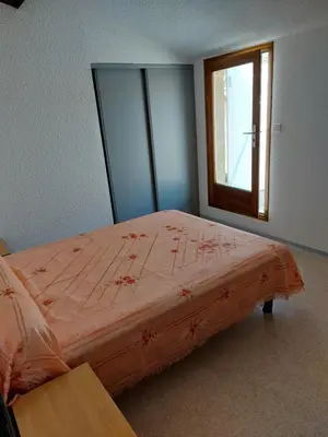 a bedroom with a large bed with a window at Gîte communal presbytère in Pézilla-de-Conflent