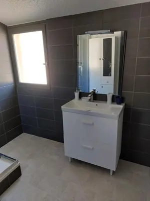 a bathroom with a sink and a mirror and a window at Gîte communal presbytère in Pézilla-de-Conflent