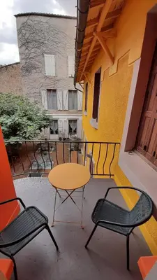 a patio with a table and chairs on a balcony at Le 9 de Cour, Chambre Kiwi in Carcassonne