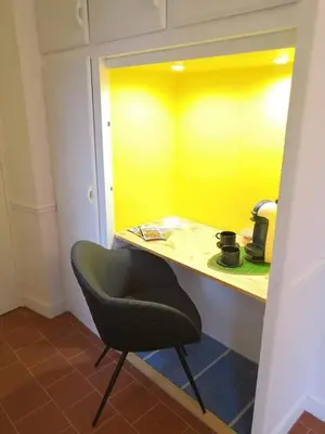 a black chair in a room with a yellow counter at Le 9 de Cour, Chambre Kiwi in Carcassonne
