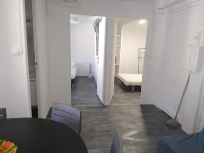 a hallway with a room with a bed and a table at APPARTEMENT 6 PERSONNES in Port-la-Nouvelle