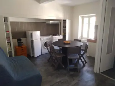 a kitchen with a table and chairs and a kitchen with a refrigerator at APPARTEMENT 6 PERSONNES in Port-la-Nouvelle