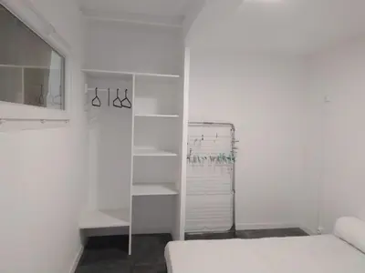 a white room with a bed and shelves at APPARTEMENT 6 PERSONNES in Port-la-Nouvelle