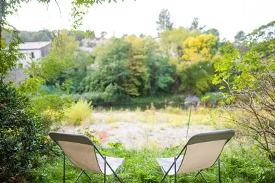 two chairs sitting in the grass near a field at The Riverside Gîte Lagrasse in Lagrasse