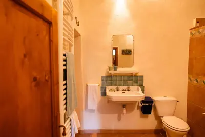 a bathroom with a sink and a toilet and a mirror at The Riverside Gîte Lagrasse in Lagrasse
