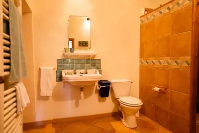 a bathroom with a toilet and a sink and a mirror at The Riverside Gîte Lagrasse in Lagrasse