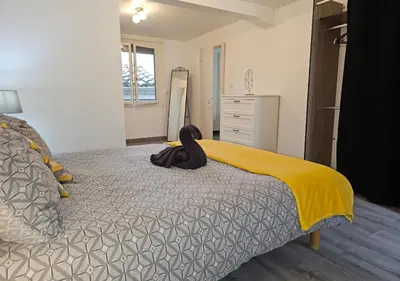 a bedroom with a bed with a black towel on it at Castelnaudary - Appartement JARDIN in Castelnaudary
