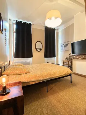 a bedroom with two beds and a flat screen tv at Rooftop Face à la Cité 'RFC' in Carcassonne