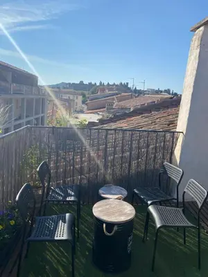 a patio with chairs and a table and a barrel at Rooftop Face à la Cité 'RFC' in Carcassonne