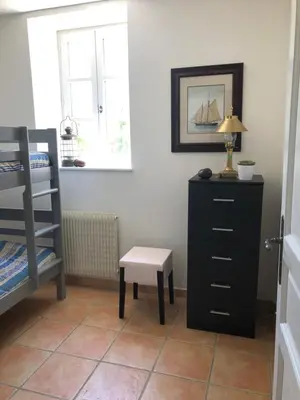 a bedroom with a bed and a dresser and a stool at The Courtyard in Castres