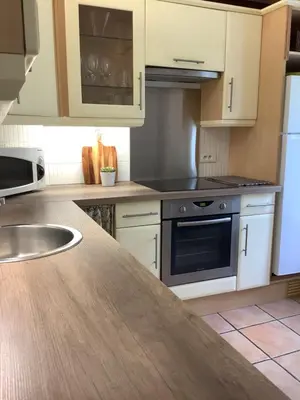a kitchen with white cabinets and a counter top at The Courtyard in Castres