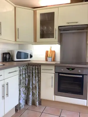 a kitchen with white cabinets and a stove top oven at The Courtyard in Castres