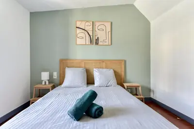 a bedroom with a bed with two pillows on it at L'Escapade - Parking Gratuit - WIFI - Climatisation - Proche Cité - Tout Equipée in Carcassonne