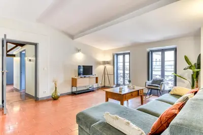 a living room with a couch and a table at L'Escapade - Parking Gratuit - WIFI - Climatisation - Proche Cité - Tout Equipée in Carcassonne