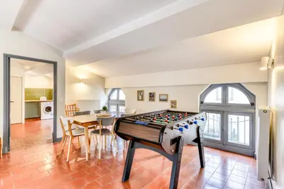a living room with a foosball table in the middle of a room at L'Escapade - Parking Gratuit - WIFI - Climatisation - Proche Cité - Tout Equipée in Carcassonne