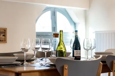 a table with wine bottles and glasses on it at L'Escapade - Parking Gratuit - WIFI - Climatisation - Proche Cité - Tout Equipée in Carcassonne