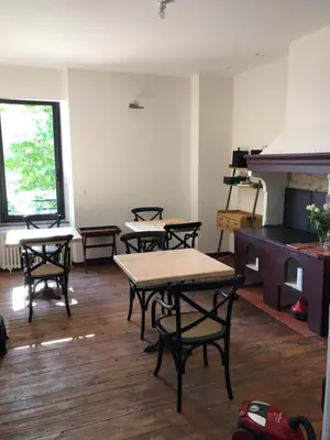 a room with tables and chairs and a piano at La villa du chai in Lézignan-Corbières