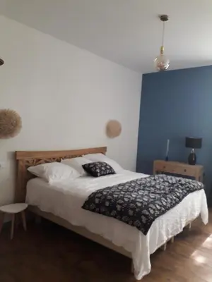a bedroom with a bed and a blue wall at La villa du chai in Lézignan-Corbières