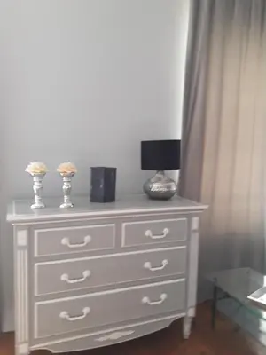 a white dresser with a lamp on top of it at La villa du chai in Lézignan-Corbières