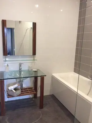 a bathroom with a sink and a tub and a mirror at La villa du chai in Lézignan-Corbières