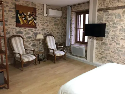 a bedroom with two chairs and a flat screen tv at Carcahouse in Carcassonne