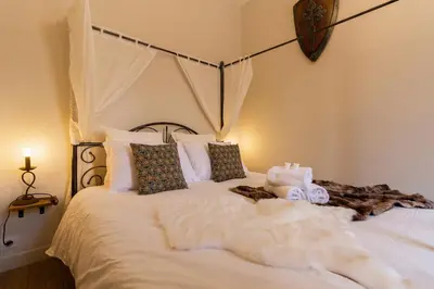 a bedroom with a bed with white sheets and pillows at Le Secret de la Taverne - Netflix/Wifi - Chasse Aux Trésor à l'intérieur in Carcassonne