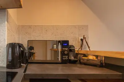a microwave oven sitting on top of a kitchen counter at Le Secret de la Taverne - Netflix/Wifi - Chasse Aux Trésor à l'intérieur in Carcassonne