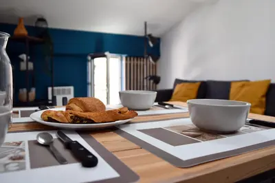 a table with a plate of bread and bowls on it at Appartement 