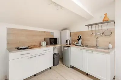 a kitchen with white cabinets and a sink at Appartement 